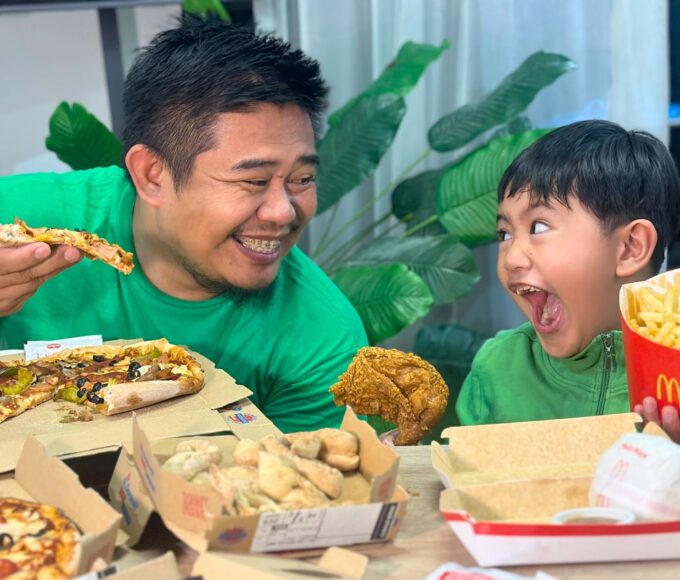 Louie, a dad in his early 40s, sitting his son Luis eating pizza & chicken — a real moment of presence from the LifeSharesTogether family
